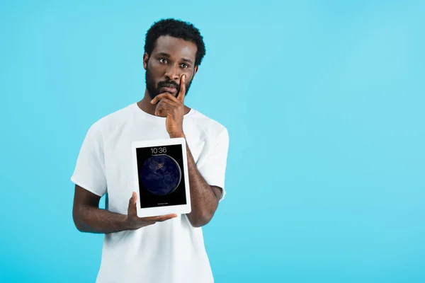 KYIV, UKRAINE - MAY 17, 2019: thoughtful african american man showing digital tablet, isolated on blue — Stock Photo