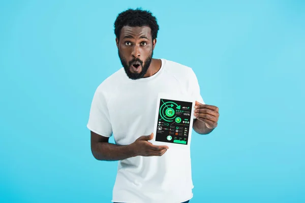 Shocked african american man showing digital tablet with infographic app, isolated on blue — Stock Photo