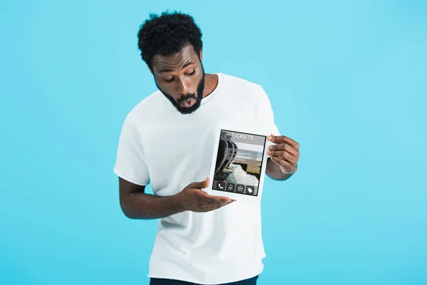 Shocked african american man showing digital tablet with tickets app, isolated on blue — Stock Photo