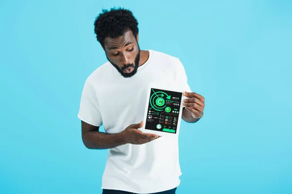 Homme afro-américain choqué montrant tablette numérique avec application infographique, isolé sur bleu — Photo de stock