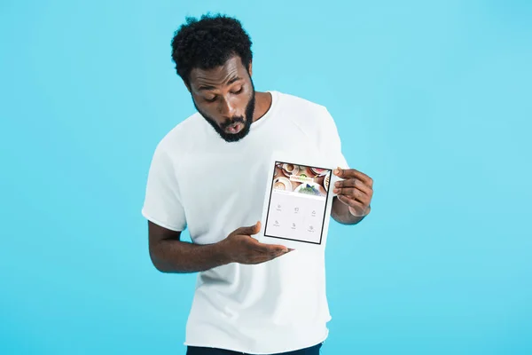 KYIV, UKRAINE - MAY 17, 2019: shocked african american man looking at digital tablet with foursquare app, isolated on blue — Stock Photo