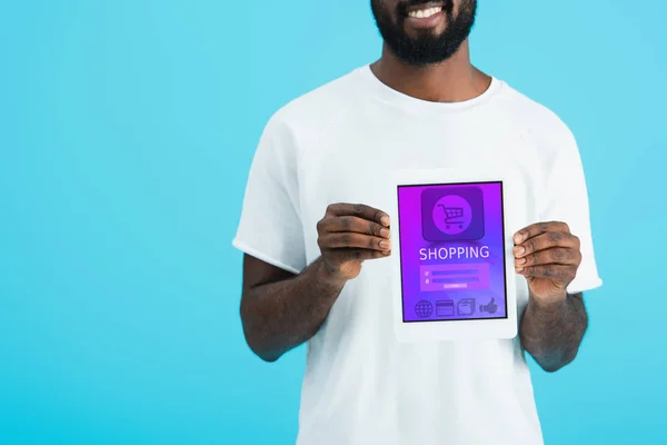 Recortado vista de hombre afroamericano mostrando tableta digital con aplicación de compras, aislado en azul — Stock Photo