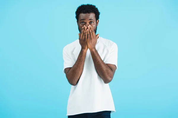 Frustrated african american man in white t-shirt closing face, isolated on blue — Stock Photo