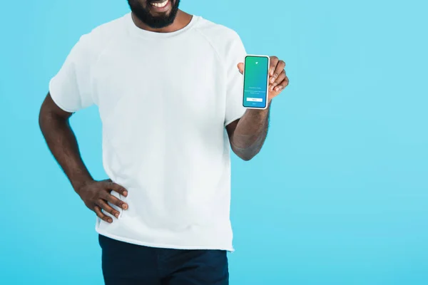 KYIV, UKRAINE - MAY 17, 2019: cropped view of african american man showing smartphone with twitter app, isolated on blue — Stock Photo