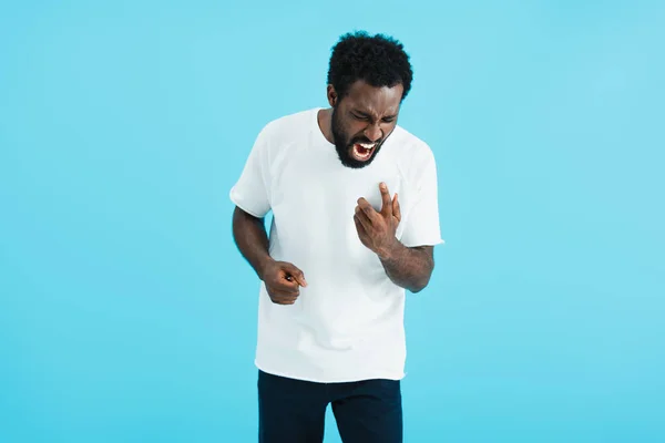 Aggressivo uomo afroamericano urla su smartphone, isolato sul blu — Foto stock