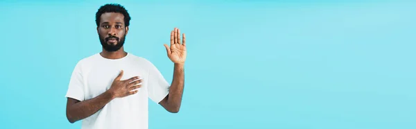 African american man swearing on heart isolated on blue — Stock Photo