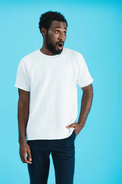 Shocked african american man in white t-shirt, isolated on blue — Stock Photo