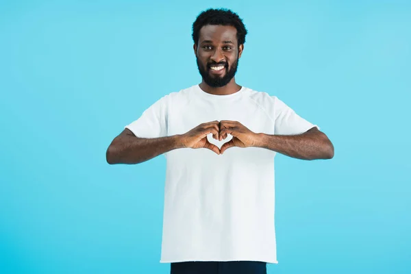 Hombre afroamericano feliz mostrando el signo del corazón aislado en azul - foto de stock