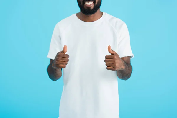 Vista recortada del hombre afroamericano mostrando pulgares hacia arriba aislado en azul - foto de stock