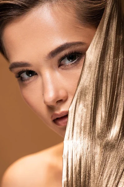 Belle femme avec feuille d'or décorative isolée sur beige — Photo de stock