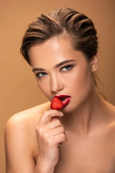 Naked beautiful woman holding strawberry and looking at camera isolated on beige — Stock Photo