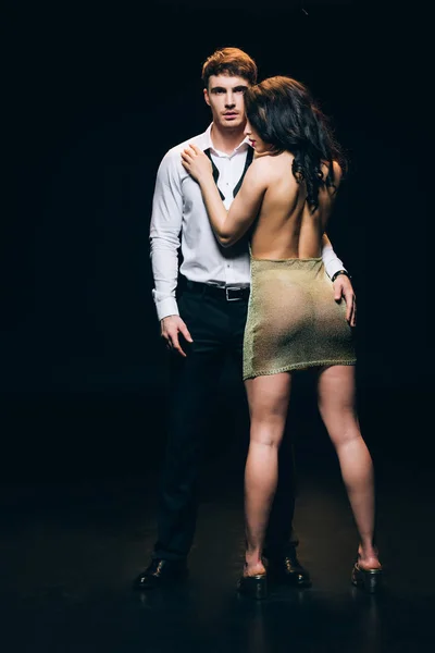 Élégant homme toucher brunette chaud femme isolé sur noir — Photo de stock