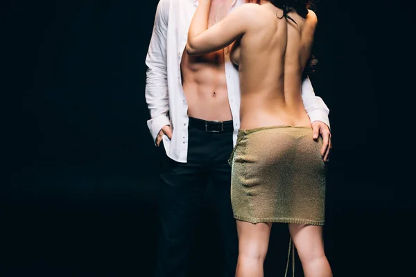 Back view of naked woman with sexy buttocks standing near elegant boyfriend with bare torso isolated on black — Stock Photo