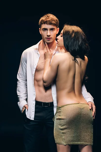 Undressed passionate woman standing near elegant sexy boyfriend with bare torso isolated on black — Stock Photo