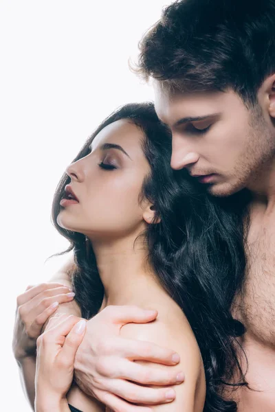 Joven pareja desnuda con los ojos cerrados abrazando aislado en blanco - foto de stock