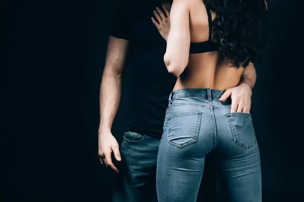 Vue recadrée de l'homme touchant petite amie fesses isolé sur noir — Photo de stock