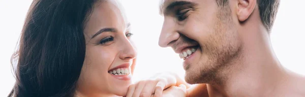 Plano panorámico de pareja joven desnuda mirándose el uno al otro y sonriendo aislado en blanco - foto de stock