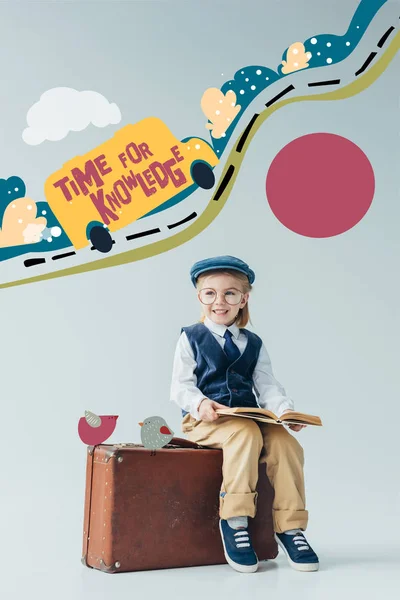 Усміхнена дитина в ретро жилеті і кепці сидить на валізі і тримає книгу на сірому фоні з машиною на дорозі фея ілюстрація і час для написання знань — стокове фото
