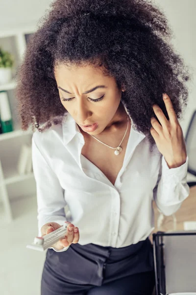 Scioccata donna d'affari afro-americana guardando il termometro in ufficio — Foto stock