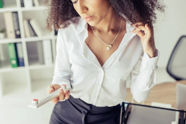 Обрізаний вид афроамериканської бізнес-леді, дивлячись на термометр в офісі — стокове фото