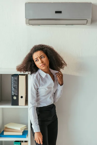 Unzufriedene afrikanisch-amerikanische Geschäftsfrau steht unter Klimaanlage und schaut weg — Stockfoto