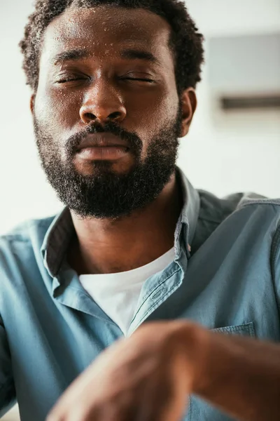 Afrikanisch-amerikanischer Mann mit Schweißperlen im Gesicht leidet unter Sommerhitze mit geschlossenen Augen — Stockfoto