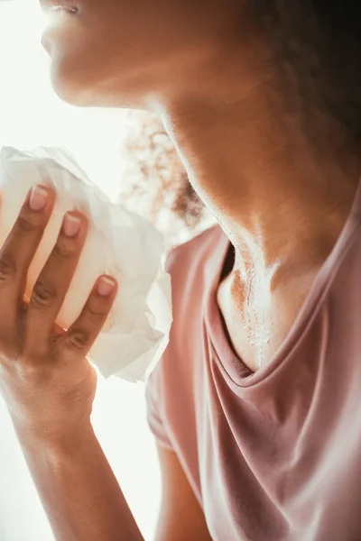 Cropped view of sweaty african american woman holding napkin while suffering from summer heat — Stock Photo