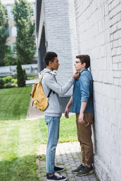 African american boy in hoodie and jeans bulling boy in glasses — Stock Photo