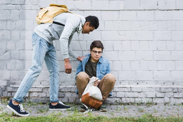 African american boy in hoodie and jeans bulling boy in glasses — Stock Photo