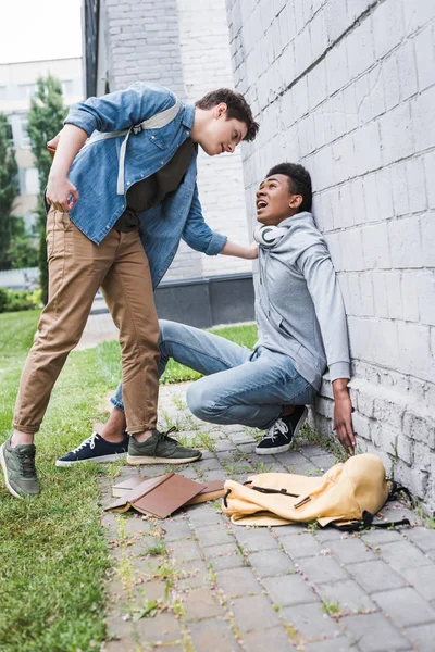 Angry boy in shirt bulling, going to punch african american boy in hoodie — Stock Photo