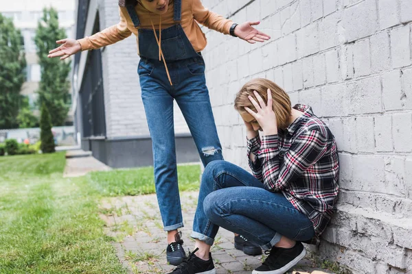 Aggressiver und brünetter Teenager brüllt Blondine an und erschreckt Teenager — Stockfoto