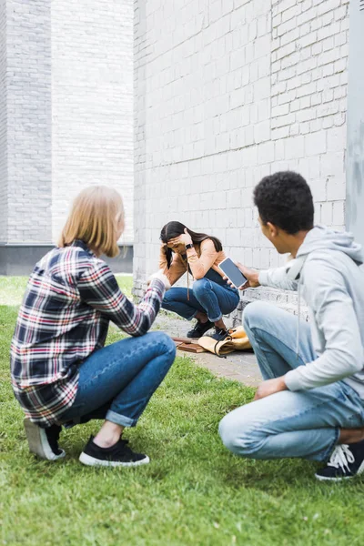 African american boy and blonde teenager shooting scared brunette teenager — Stock Photo