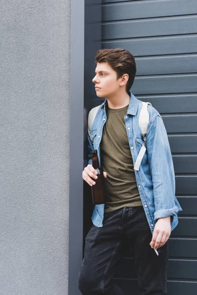 Boy looking away, smoking cigarette and drinking beer outside — Stock Photo