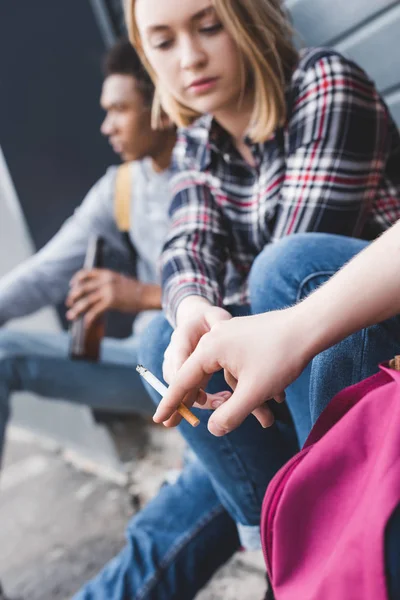 Concentration sélective des adolescents assis, buvant de la bière et tenant une cigarette — Photo de stock