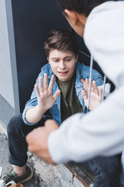 Selective focus of african american boy punching scared boy in shirt — Stock Photo