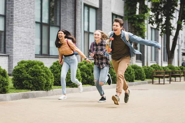 Грайливий і щасливий підлітків працює з скейтбордом і посміхаючись — стокове фото