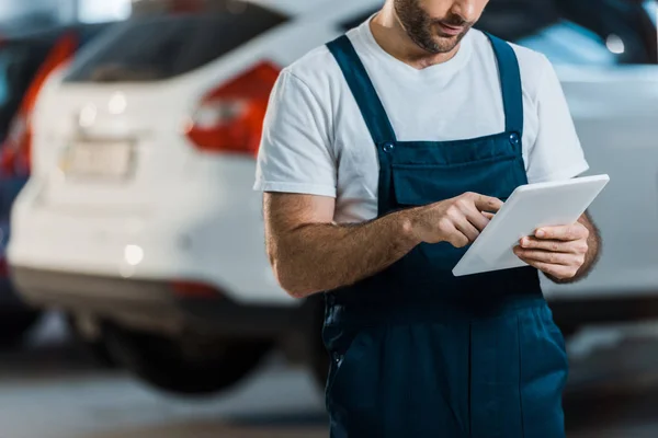 Обрізаний вид механіка автомобіля з використанням цифрового планшета в автосервісі — стокове фото