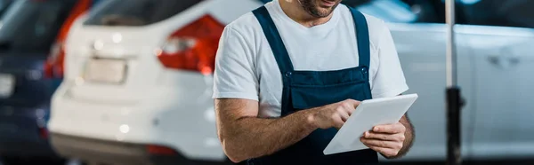 Prise de vue panoramique de mécanicien de voiture en utilisant la tablette numérique dans le service de voiture — Photo de stock