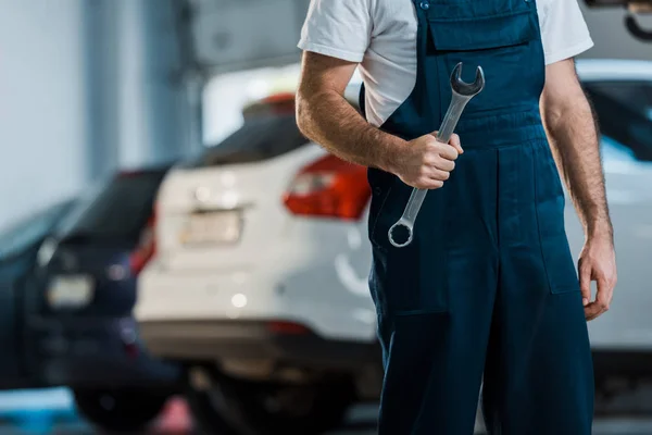 Cropped view of car mechanic holding hand wrench in car service — Stock Photo
