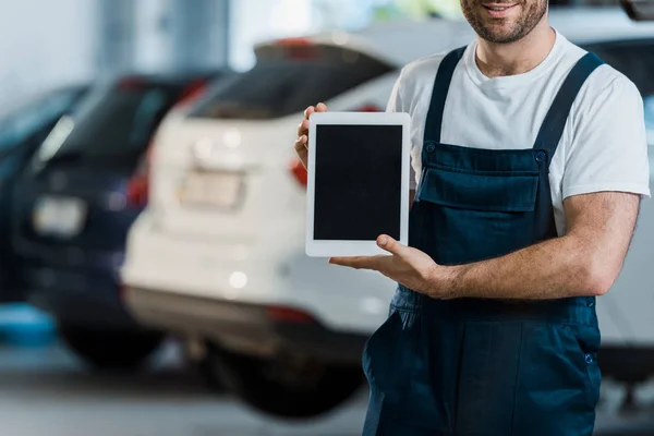 Vista ritagliata di allegro meccanico auto con tablet digitale con schermo bianco — Foto stock