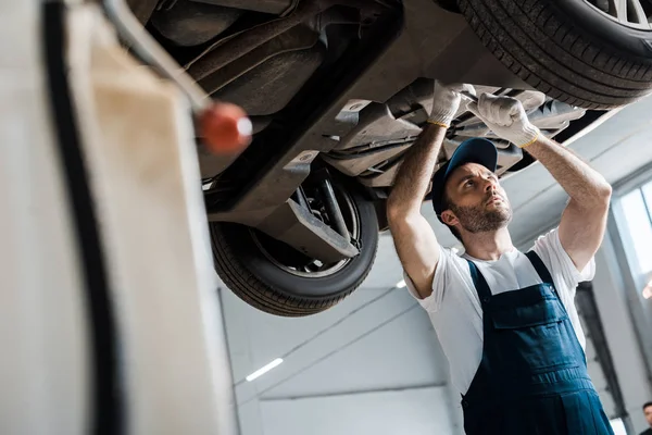 Enfoque selectivo de la mecánica del coche barbudo reparación de automóviles en el servicio de automóviles - foto de stock