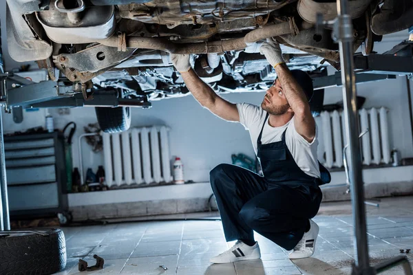 Selektiver Fokus des gutaussehenden Automechanikers, der Autos repariert — Stockfoto