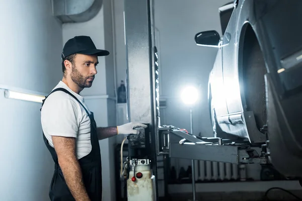 Mécanicien automobile en casquette debout près de l'automobile en service de voiture — Photo de stock