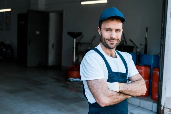 Glücklicher bärtiger Automechaniker mit verschränkten Armen — Stockfoto