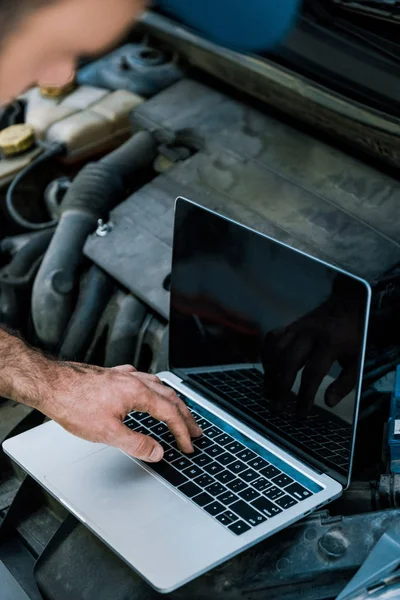 Abgeschnittene Ansicht von Automechaniker mit Laptop mit leerem Bildschirm in der Nähe des Autos — Stockfoto