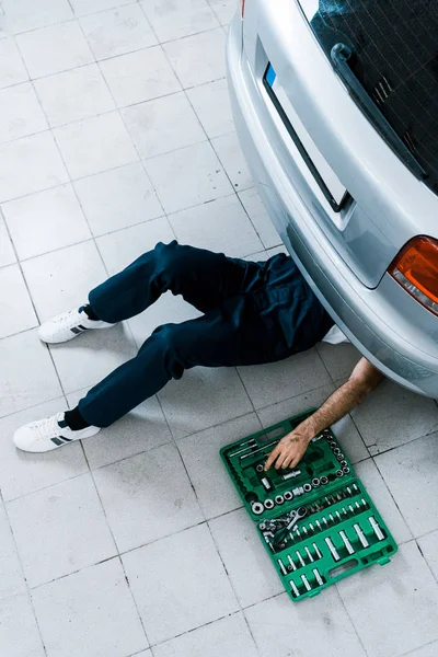 Overhead view of auto mechanic repairing car in car service — Stock Photo