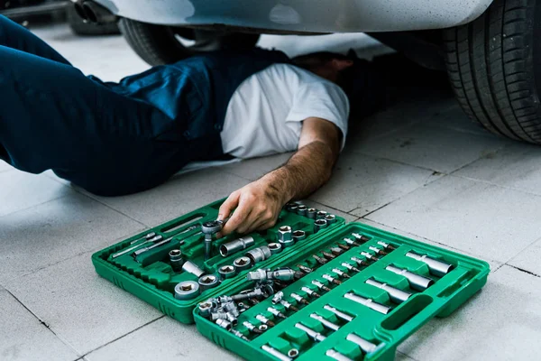 Cropped view of car mechanic repairing car in car service — Stock Photo