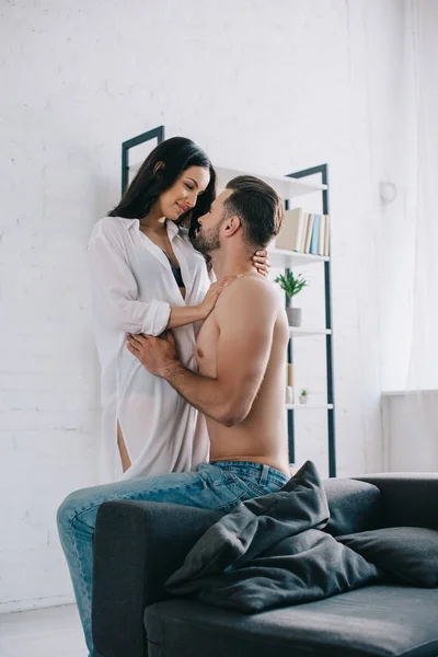 Attrayant et brunette femme en chemise câlin avec homme torse nu — Photo de stock