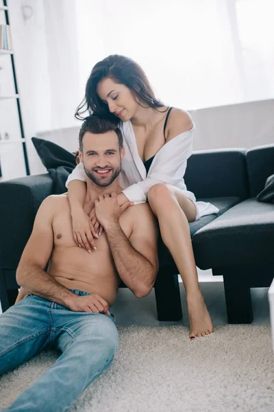 Attrayant et souriant femme en chemise câlin avec torse nu et bel homme — Photo de stock