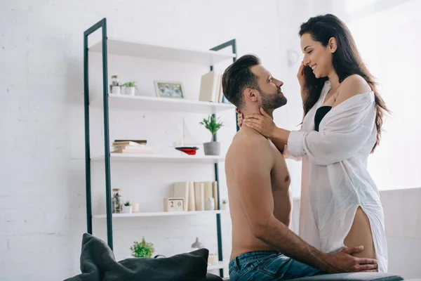 Attractive and smiling woman in shirt hugging with handsome man — Stock Photo